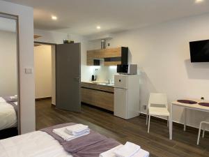 a room with a bed and a kitchen with a counter at M70 Apartmanház in Miskolc
