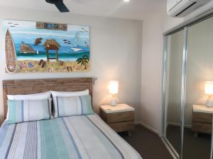 una camera da letto con un letto con due comodini e due lampade di BEACH Luxury Upmarket 2B 2B OCEAN VIEWS 250m to BUDDINA BEACH! a Buddina Altre 42 foto