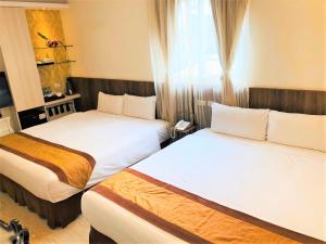 a hotel room with two beds and a window at Taitung Z. Hotel in Taitung City