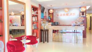 un restaurant avec des chaises rouges, une table et un comptoir dans l'établissement Taitung Z. Hotel, à Taïtung