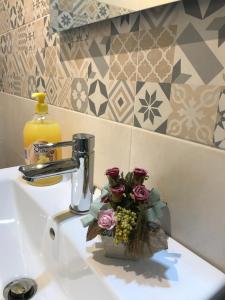 ein Waschbecken im Badezimmer mit einer Vase mit Blumen darauf in der Unterkunft Le sorelle gemelle B&B in Teramo + 156 Fotos