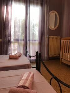 ein Schlafzimmer mit zwei Betten und einem Fenster mit Vorhängen in der Unterkunft Le sorelle gemelle B&B in Teramo