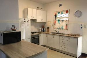 a kitchen with white cabinets and a black appliance at B2 Crawley Apartment 1 BRM & Sleepout near UWA in Perth