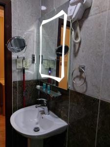 a bathroom with a sink and a mirror at Beyoot Alsharq Furnished Units in Al Khobar