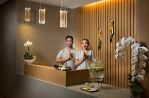 a man and woman standing in front of a mirror at Millennium Place Barsha Heights Hotel in Dubai