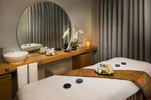 a bathroom with two beds and a sink and a mirror at Millennium Place Barsha Heights Hotel in Dubai