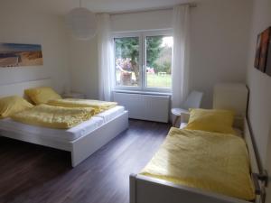 two beds in a room with a window at Ferienwohnung Eyb in Ansbach