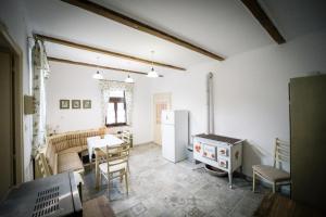 a kitchen with a refrigerator and a table and chairs at Spalettás Porta - Vidéki Vendégház in Őrtilos