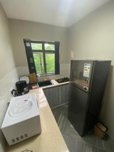 a kitchen with a refrigerator and a counter with a microwave at KSTUDIOS in Grand-Baie