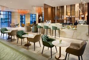 a restaurant with tables and chairs and a bar at Millennium Place Barsha Heights Hotel in Dubai