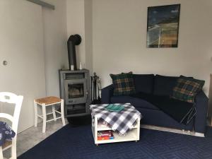 ein Wohnzimmer mit einem blauen Sofa und einem Herd in der Unterkunft Ferienhaus Dierhagen Strand I & II in Dierhagen