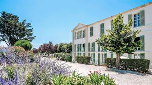 a large building with a garden in front of it at Appartement les gouverneurs in Saint-Martin-de-Ré