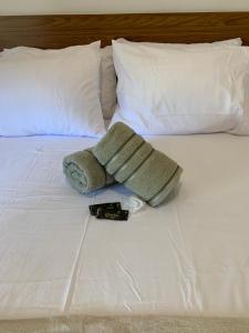 Una cama con una toalla y un mando a distancia. en Sweet Home, en Río de Janeiro