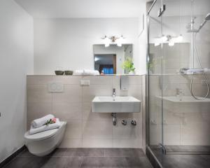 a bathroom with a toilet and a sink and a shower at Bayern Resort Hotel - Adults only - mit Zugspitzblick - Eibsee-Nähe - Wellnessbereich - Naturpool im Sommer in Grainau