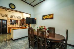 una sala da pranzo con tavolo e TV di Leo's Home Stay a Colombo