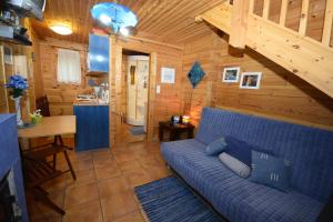 una sala de estar con un sofá azul en una cabaña en Agroktima Armonia, en Karpenisi