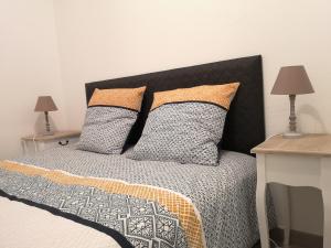 um quarto com uma cama com dois travesseiros em LE WILSON SUITE - Centre-ville - Gare - Tram em Mulhouse