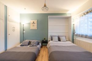 two beds in a room with blue walls at Cosy Studio 110 - Chambéry centre - Stationnement - Gare in Chambéry