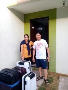 Dois homens em frente a um edifício com a bagagem. em Haus of Emerald by JeYo em Mactan mais 206 fotografias