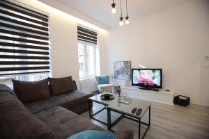 a living room with a couch and a tv at Miaap Apartments in Sarajevo