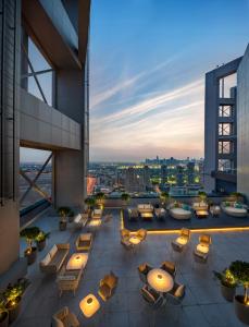 a rooftop patio with tables and chairs on a building at Millennium Place Barsha Heights Hotel in Dubai