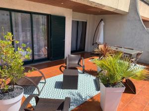 a patio with chairs and a table and some plants at San Felix Paradise Beach Piscine Porto in São Félix da Marinha