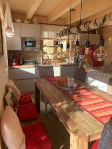 cocina con mesa de madera y sillas acolchadas de color rojo en Chalet Die Berghexn, en Klippitztorl