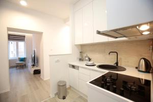 a kitchen with white cabinets and a black sink at Miaap Apartments in Sarajevo