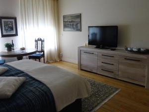 een slaapkamer met een bed en een flatscreen-tv bij Gastsuite in Valkenburg aan de Geul in Valkenburg
