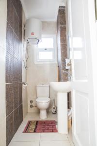 a bathroom with a toilet and a sink and a window at Breathtaking Wide Seaview Apartment in Alexandria +21 photos