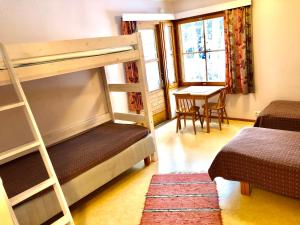 a bedroom with a bunk bed and a table with a desk at Salonsaaren Lomakylä in Asikkala