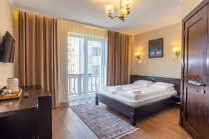 a bedroom with a bed and a large window at Amarena SPA Hotel - Breakfast included in the price Spa Swimming pool Sauna Hammam Jacuzzi Restaurant inexpensive and delicious food Parking area Barbecue 400 m to Bukovel Lift 1 room and cottages in Bukovel