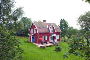 a red house with a deck in the yard at Klappa in Malmbäck
