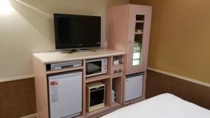 a room with a tv on a cabinet with a television at Hotel GOLF Yokohama (Adult Only) in Yokohama