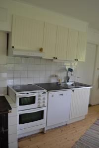 a kitchen with white appliances and a sink at Klappa in Malmbäck