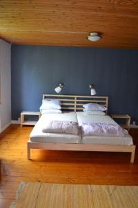 a bedroom with a large bed with a blue wall at Klappa in Malmbäck