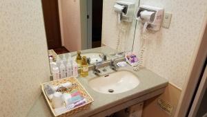a bathroom with a sink and a mirror at Hotel GOLF Yokohama (Adult Only) in Yokohama