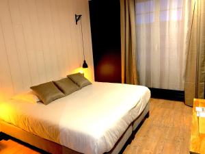 ブーズヴィルにあるHôtel-Spa-Piscine Le Petit Castel Beuzeville-Honfleurのベッドルーム1室(白いベッド1台、枕2つ付)