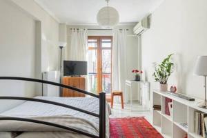 ein Schlafzimmer mit einem Bett und einem Fernseher darin in der Unterkunft Irodotou Studio in Thessaloniki