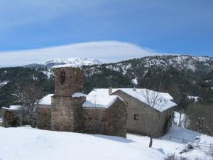 un vecchio edificio in mattoni nella neve con una montagna di Casa Javier a Bisaurri