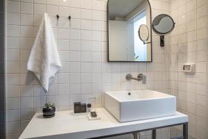 a bathroom with a sink, mirror and bath tub at Artist Hotel - an Atlas Boutique Hotel in Tel Aviv