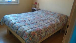 Una cama con un edredón colorido en un dormitorio en Gîte HEINTZ en Schleithal