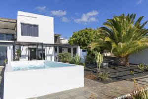 a white house with a swimming pool in the yard at Casa Amanecer in Tías