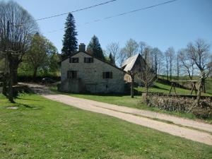 una vieja casa de piedra al lado de un camino de tierra en Maison à la ferme avec Pêche, en Roumégoux