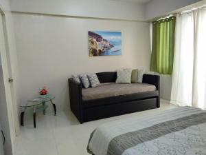 una sala de estar con un sofá y una cama en One Palm Tree Villas close to Manila Airport - Terminal 3, en Manila
