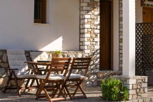 a wooden table and chairs on a patio at Villa Victoria by La Scala Beach in Limenas