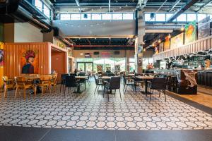 a restaurant with tables and chairs in a room at The Spot Hostel in Tel Aviv