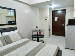 a bedroom with a bed and a table and a door at One Palm Tree Villas close to Manila Airport - Terminal 3 in Manila