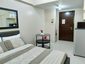 Un dormitorio con una cama y una mesa y una puerta. en One Palm Tree Villas close to Manila Airport - Terminal 3, en Manila