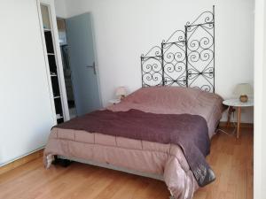 a bedroom with a large bed with a metal headboard at REZ DE VILLA SIX-FOURS in Six-Fours-les-Plages